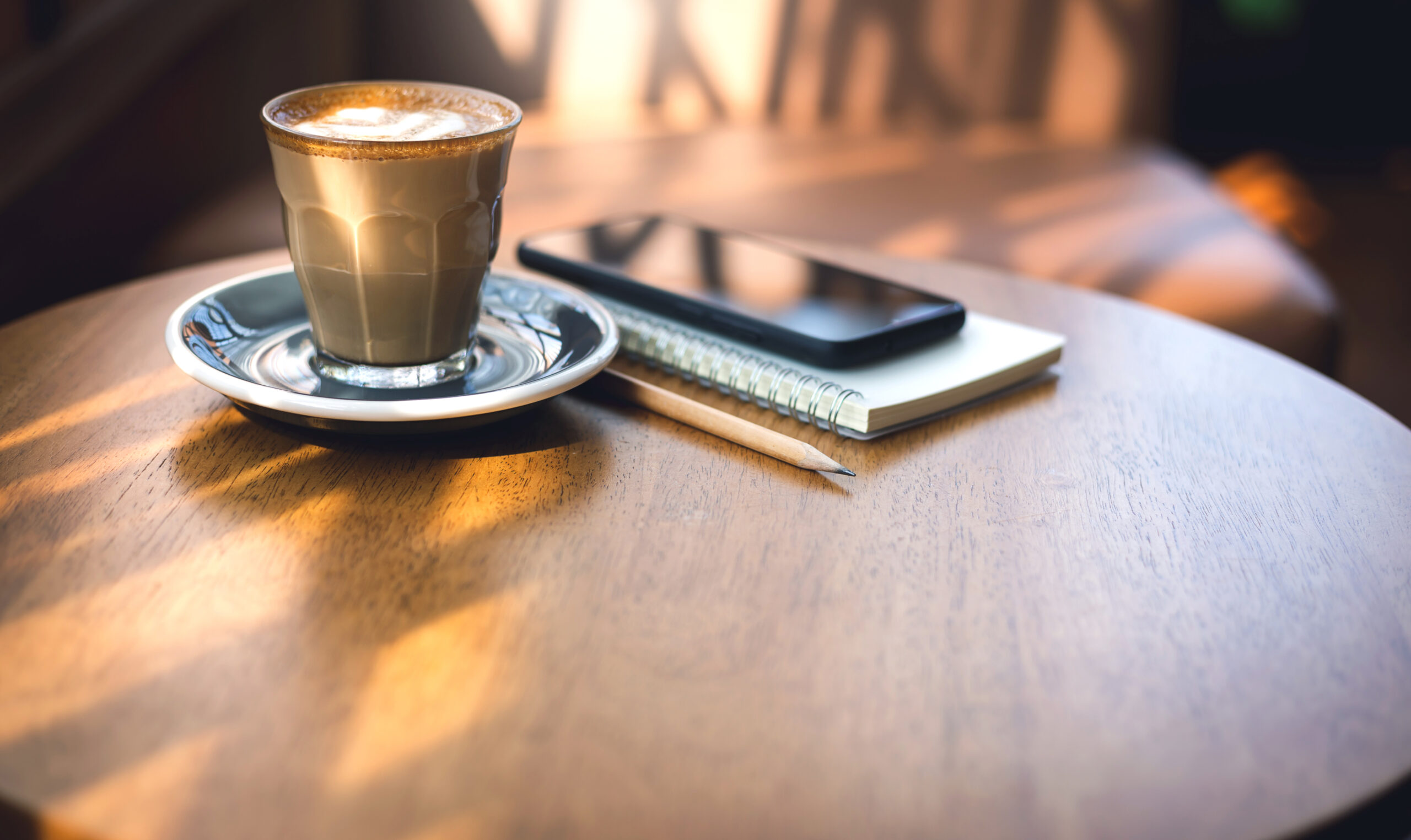 カフェのテーブルに置かれたコーヒーとスマートフォン